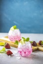 Pink cocktail with lime, crushed ice, strawberries and mint on the light background, selective focus image, copy spice for you Royalty Free Stock Photo