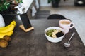 Pink coffee cup, chopped fruits in bowl and blueberries, spoon, phone in kitchen Royalty Free Stock Photo