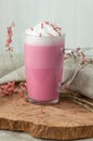 Pink coffee latte macchiato in a glass cup on a wooden backing decorated with dried flower Royalty Free Stock Photo