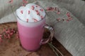 Pink coffee latte macchiato in a glass cup on a wooden backing decorated with dried flower Royalty Free Stock Photo