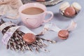 Pink coffee mug with sweet pastel french macaroons and wil