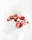 Pink cololred quail Easter eggs in white napkin, closeup view