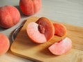Pink color peach fruit cut in half. Royalty Free Stock Photo