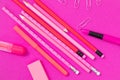 Pink color writing equipment scattered on pink surface isolated