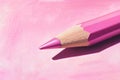 Pink colored pencil resting on pink paper creating a shadow Royalty Free Stock Photo
