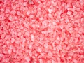 Pink colored salt crystals as a background. Aromatic roseate bath salt with litchi and patchouli scent. Large sprinkled Royalty Free Stock Photo