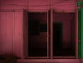 Pink colored vintage wooden shop door at village