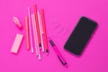 Pink colour office requisites and one black smart phone on pink background cutout