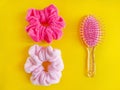 Pink comb and bright spiral scrunchies on the yellow background.