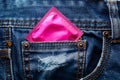 Pink condom in the pocket of blue jeans Royalty Free Stock Photo