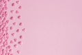 Pink confectionery hearts located on left side on pink background, greeting card, copy space Royalty Free Stock Photo