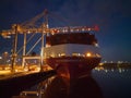 Pink container ship bow at night at Southampton Docks UK aerial with port crane Royalty Free Stock Photo