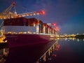 Pink container ship at night at Southampton Docks UK aerial side view Royalty Free Stock Photo