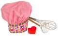 Pink cooking hat, with multi-colored pattern, hearts, flowers and owls. Hearts molds for cookies in red. Whisk to froth Royalty Free Stock Photo