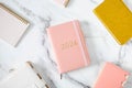 Pink coral colored diary for the year 2024 and many other diaries, pen, marble background Royalty Free Stock Photo
