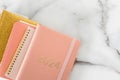 Pink coral colored diary for the year 2024 and many other diaries, pen, marble background Royalty Free Stock Photo