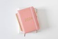 Pink coral colored diary for the year 2024 and many other diaries, pen, white background Royalty Free Stock Photo