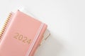 Pink coral colored diary for the year 2024 and many other diaries, pen, white background Royalty Free Stock Photo