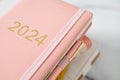 Pink coral colored diary for the year 2024, pen, marble background Royalty Free Stock Photo