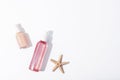 Pink cosmetic bottles and starfish on white background with sharp shadows. Natural cosmetics, skin care concept. Top Royalty Free Stock Photo