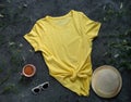 Yellow plain t-shirt mockup coffee cup dark background. Blank cotton shirt template creative design. Female illuminating summer Royalty Free Stock Photo