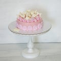 A pink creamchease cake with flowers for 5 year birhtday