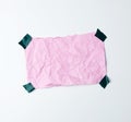 Pink crumpled sheet of paper glued with adhesive tape on a white background Royalty Free Stock Photo