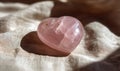 A pink crystal heart is on a white cloth Royalty Free Stock Photo