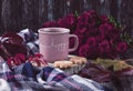 A pink cup of coffee, burgundy asters, autumn grape leaves, cookies and a scarf.