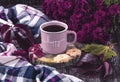 A pink cup of coffee, burgundy asters, autumn grape leaves, cookies and a scarf. Happy autumn mood.