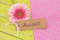 Pink daisy gerbera flower with gift tag and german word, Auszeit, means timeout or relax Royalty Free Stock Photo