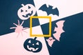 pink-dark blue background with paper monsters around orange frame, halloween creative concept