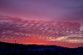 Pink dawn over a small town. City silhouette with a beautiful sunset. Dark winter landscape, outlines of mountain and forest Royalty Free Stock Photo
