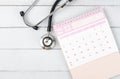 The Pink December 2023 desk calendar and stethoscope medical on wooden background, schedule to check up healthy concepts Royalty Free Stock Photo