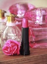 Pink decorative lipstick on the background of perfume bottles Royalty Free Stock Photo
