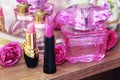 Pink decorative lipstick on the background of perfume bottles Royalty Free Stock Photo