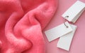 Pink delicate soft background of plush fabric folds on pink background and mini notepad Copy space. Flat lay. Details of warm