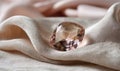 A pink diamond is on a white cloth Royalty Free Stock Photo