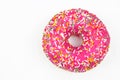 Pink donut decorated with colorful sprinkles. Flat lay. Top view Royalty Free Stock Photo