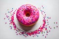 Pink donut decorated with colorful sprinkles isolated on white background. Top view Royalty Free Stock Photo