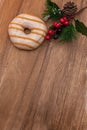 Pink Donut in glaze and festive pine branch on wooden natural background