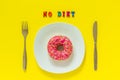 No diet and Pink donut on white plate and knife fork on yellow background.