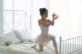 Pink dresses little girl 9 year dancing ballet with white bed in bedroom at home, Ballerina young girl practicing ballet