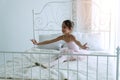 Pink dresses little girl 9 year dancing ballet with white bed in bedroom at home, Ballerina young girl practicing ballet