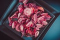 Pink dried flowers petals potpourri on black backrgound.