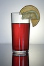 Pink drink in a glass glass Cup with reflection, a slice of lemon and orange Royalty Free Stock Photo