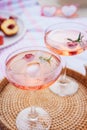 Pink drinks, cocktail with ice, raspberry, rosemary. Two glasses with martini, champagne, cider, lemonade on the blanket