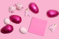 Pink Easter background with Easter eggs, decorations and pink blank sticky note paper.