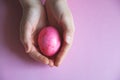 Pink Easter egg in children`s palms Royalty Free Stock Photo