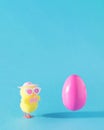 Pink Easter egg flying. Modern yellow chicken with sun glasses and hat. Spring summer sunny concept idea